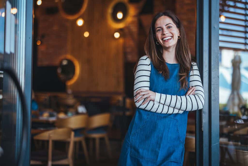 woman standing in the doorway of her business