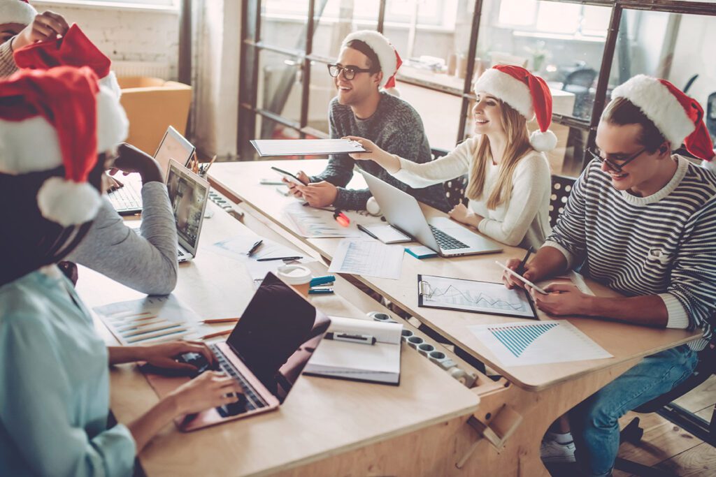 marketing team wearing christmas hats during a meeting